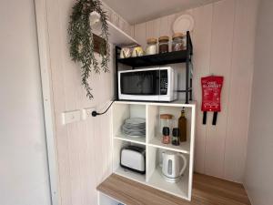 a small kitchen with a microwave on a shelf at Tiny House Adventure by Tiny Away in Tallarook