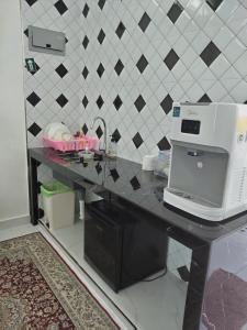 a counter with a microwave on top of a table at Makwan Homestay D in Kubang Semang