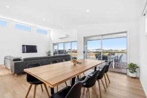 a living room with a table and chairs and a couch at Lagoon Views in Hindmarsh Island