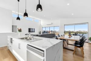 a kitchen and living room with a table and chairs at Lagoon Views in Hindmarsh Island