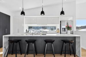 a kitchen with a large island with bar stools at Lagoon Views in Hindmarsh Island
