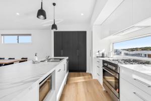 a kitchen with white counters and a large window at Lagoon Views in Hindmarsh Island +31 photos