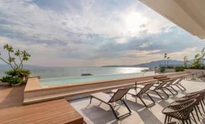 a pool with chairs and a view of the ocean at Maralma Bucerias 1 half Blocks from Beach Sleeps 4 in Bucerías