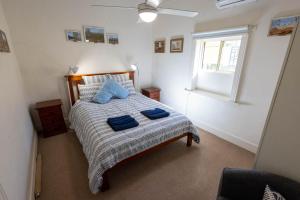 a bedroom with a bed with two blue pillows on it at Hawker Bed and Breakfast in Hawker