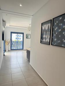 a hallway with white walls and pictures on the wall at Luxury Apartment in martil in Martil