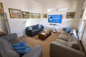 a living room with couches and a flat screen tv at Hawker Bed and Breakfast in Hawker
