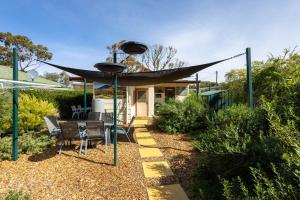 a patio with a table and a black umbrella at Hawker Bed and Breakfast in Hawker