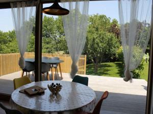 a patio with a table and chairs and a large window at Valomerius Charming holiday home in Maarkedal