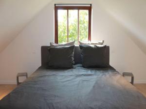 a bed with pillows in a room with a window at Valomerius Charming holiday home in Maarkedal