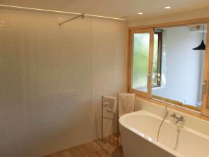a bathroom with a tub and a glass shower at Valomerius Charming holiday home in Maarkedal +13 photos