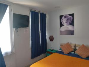 a bedroom with a bed and a tv and a window at hostal mancora in Santiago