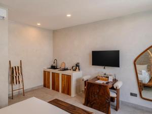a living room with a flat screen tv on the wall at Kala Lombok Hotel in Kuta Lombok