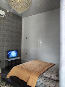 a bedroom with a bed and a tv in it at Makwan Homestay C in Kubang Semang +8 photos
