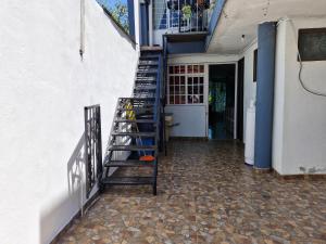 eine Treppe, die zu einem Gebäude mit einer Tür hinaufführt in der Unterkunft Casa Nicolette in Uruapan del Progreso