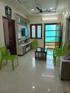 a living room with green chairs and a table at Sri Durga Nilayam in Bhadrāchalam