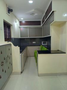 a kitchen with gray cabinets and a black counter top at Sri Durga Nilayam in Bhadrāchalam +5 photos