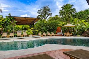 a swimming pool with chairs and a pavilion at Noah's Hideaway by Tifakara in Fortuna