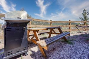 a grill and a picnic table next to a fence at Sunrise Cabin at Highland Meadows - King Bed and Views in Hot Springs
