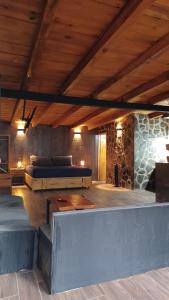 a bedroom with two beds and a stone wall at Mazamitla Pinos del Rio in Mazamitla