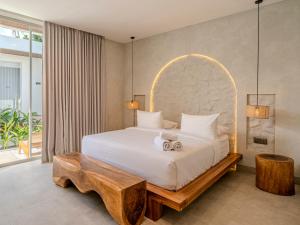 a bedroom with a large white bed with a wooden table at Kala Lombok Hotel in Kuta Lombok +36 photos