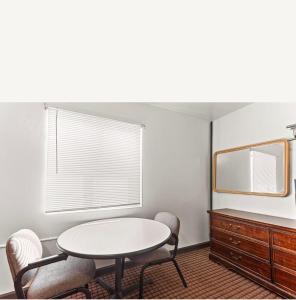a room with a table and chairs and a mirror at Budget INN in Flint