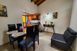 a living room with a table and chairs and a kitchen at Apartahotel Balcones de Nariño in Villa de Leyva