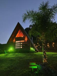 a small palm tree in front of a house at night at Chalés Três Lagoas in Alfredo Wagner