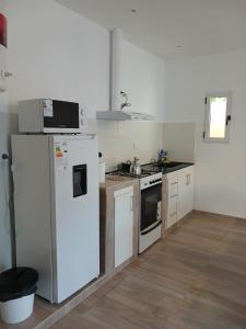 a kitchen with a white refrigerator and a stove at Listo para vos in RSA