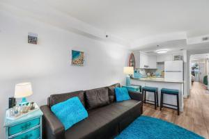 a living room with a couch and a kitchen at Oceanfront 1BR Condo Daytona Resort Pool Access in Daytona Beach