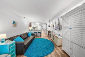 a living room with a couch and a blue rug at Oceanfront 1BR Condo Daytona Resort Pool Access in Daytona Beach