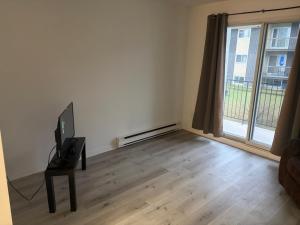 ein Wohnzimmer mit Fernseher und großem Fenster in der Unterkunft EasyStay in Sherbrooke
