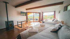 a living room with two beds and a fireplace at Hotel Patagonia House in Coihaique