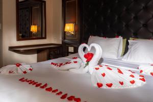 two swans dressed in white are sitting on a bed at Halong Luxury Cruise in Ha Long