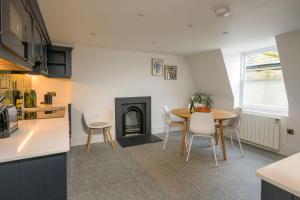 a kitchen and dining room with a table and a fireplace at Milsom Loft in Bath