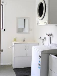 a white bathroom with a sink and a mirror at Friends With Bienefelts in Turners Beach +23 photos