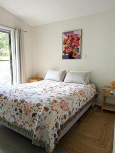 a bedroom with a bed with a floral bedspread at Friends With Bienefelts in Turners Beach