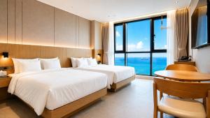a bedroom with two beds and a desk and a window at Hotel Laon in Busan +116 photos