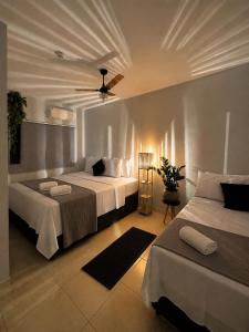 a bedroom with two beds and a ceiling fan at Hotel Santorini in Trindade