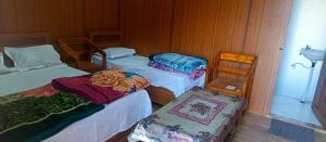 a room with three beds and a chair and a sink at trigun pahadi hub in Uttarkāshi +12 photos