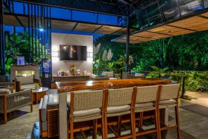 a restaurant with a bar with chairs and plants at Noah's Hideaway by Tifakara in Fortuna