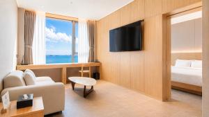 a hotel room with a bed and a television at Hotel Laon in Busan