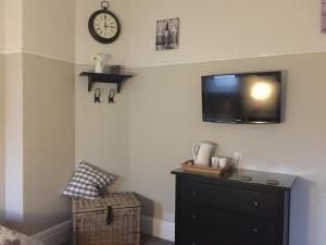 a bedroom with a dresser and a tv on the wall at The Old Crown Inn in Sheffield