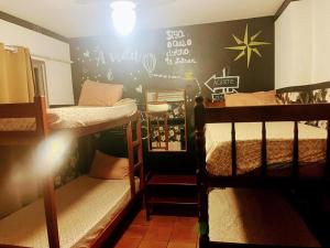 a room with two bunk beds and a wall with writing at Toca da Mona Roots Hostel in Vitória