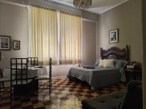 a bedroom with a bed and a couch and a window at Loft no Hotel Quitandinha Experiência Única in Petrópolis