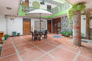 a patio with a table and chairs and an umbrella at Oleajes Capurganá in Capurganá