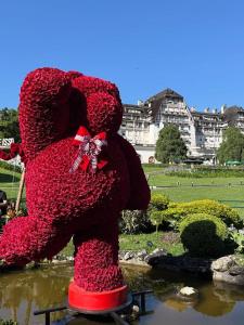 a large red teddy bear statue in a garden at Loft no Hotel Quitandinha Experiência Única in Petrópolis