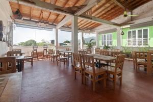 a dining room with tables and chairs and windows at Oleajes Capurganá in Capurganá