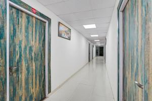 an empty hallway in an office building with a large door at Super Hotel O Greater Noida West Link Road Formerly Advent in Noida