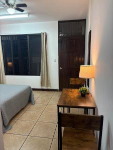 a bedroom with a bed and a table with a lamp at Luca in San José