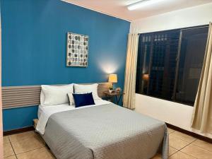 a blue room with a bed and a window at Luca in San José